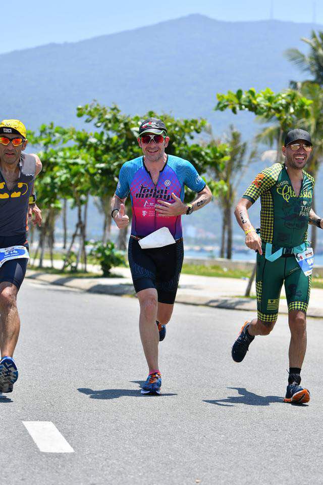 3 triathletes running in the sun