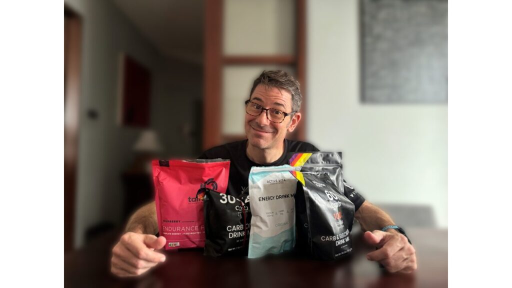 andrew sitting with various carb mixes / products on a table in front of him